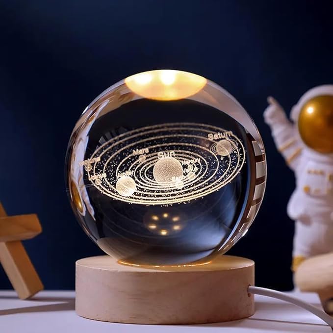 Solar System crystal ball night lamp lit warm white on its wooden base