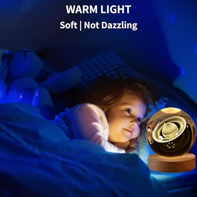 Saturn crystal ball night lamp lit warm white on its wooden base