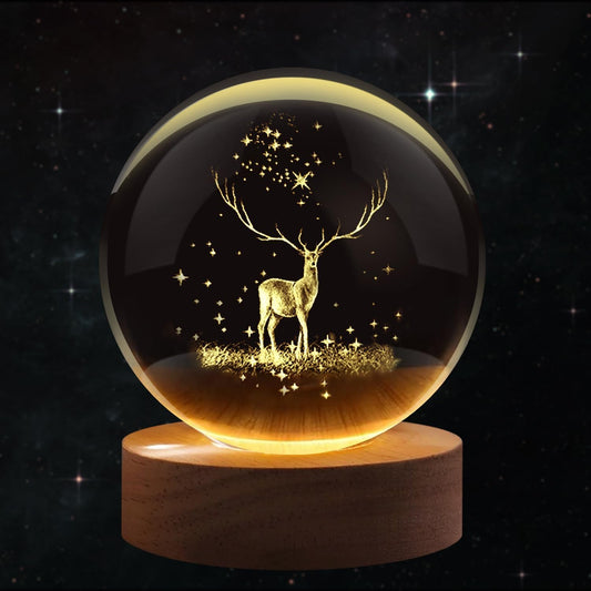 Deer crystal ball night lamp lit warm white on its wooden base