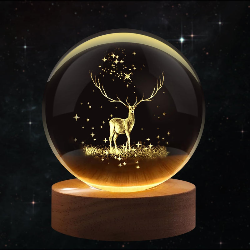 Deer crystal ball night lamp lit warm white on its wooden base