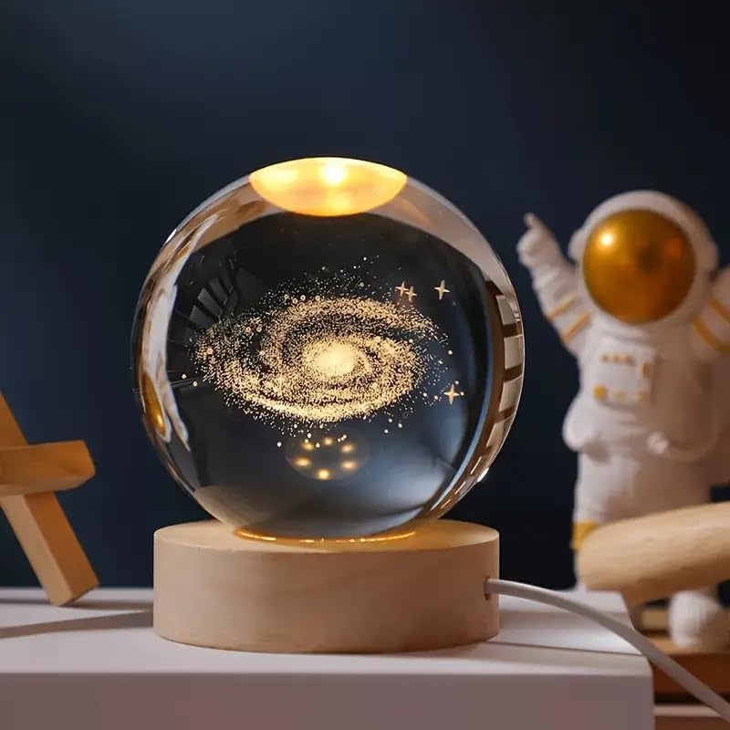 Galaxy crystal ball night lamp lit warm white on its wooden base
